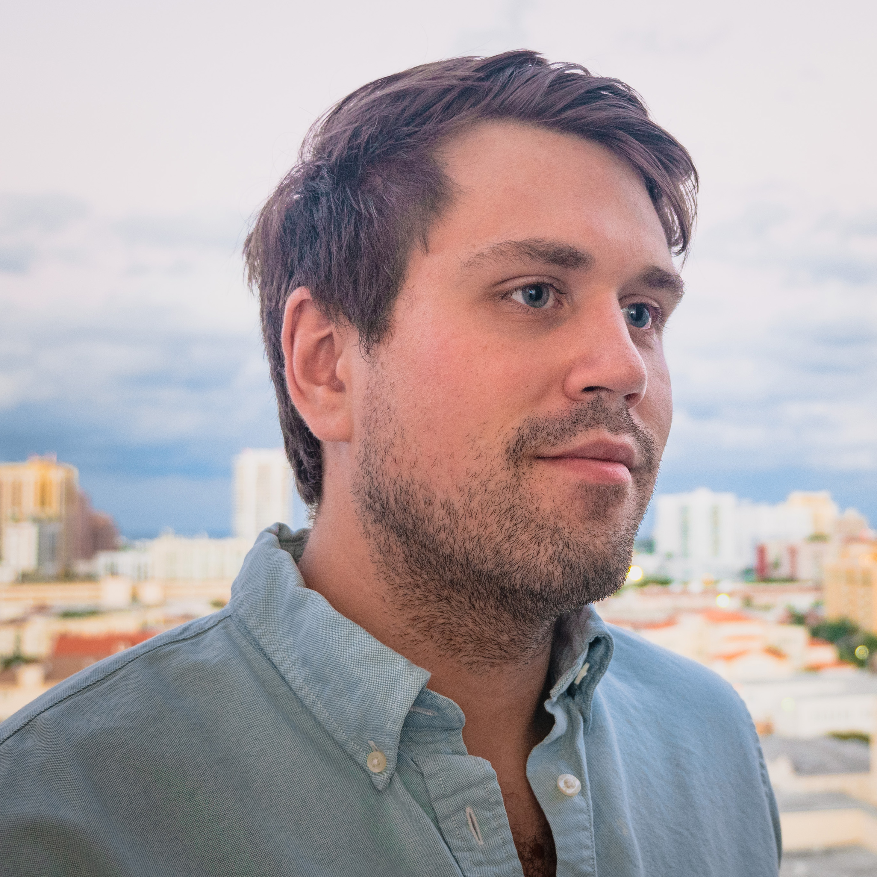 a headshot portrait of a person standing on a balcony